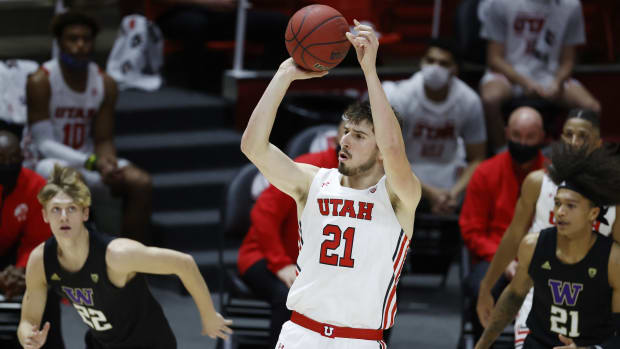 Dec 3, 2020; Salt Lake City, Utah, USA; Utah Utes forward Riley Battin (21) shoots in the second half against Washington Huskies guard Cole Bajema (22) and guard RaeQuan Battle (21) at the Jon M. Huntsman Center.